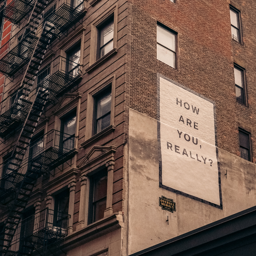 How are you really-square ¿Cómo estás realmente? Letrero en el lado del edificio